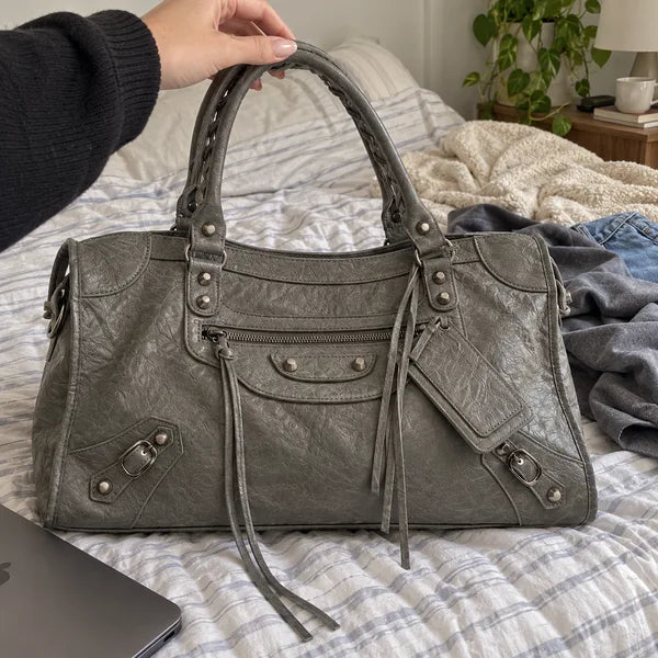 Immagine generata con IA: borsa It Girl grande, grigio scuro, in un contesto quotidiano