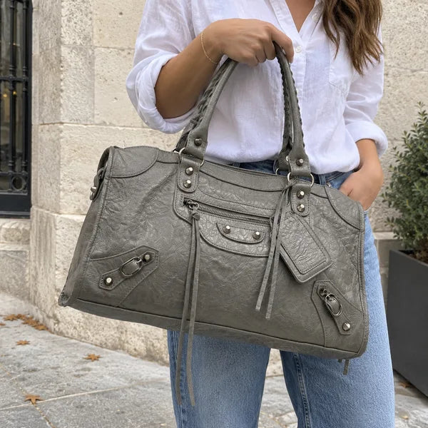 Immagine generata con IA: borsa It Girl grande, grigio scuro, in un contesto quotidiano