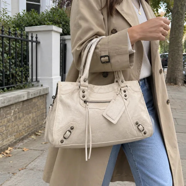 Immagine generata con IA: borsa It Girl media, beige chiaro, in un contesto quotidiano