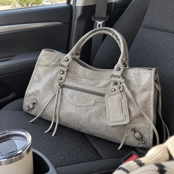 Immagine generata con IA: borsa It Girl media, grigio chiaro, in un contesto quotidiano