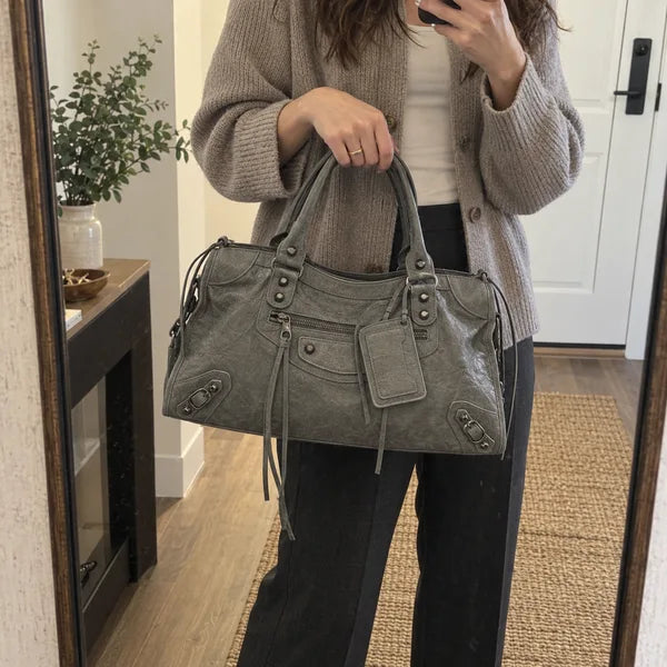Immagine generata con IA: borsa It Girl media, grigio scuro, in un contesto quotidiano