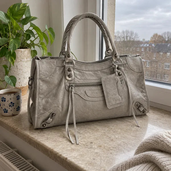 Immagine generata con IA: borsa It Girl media, grigio chiaro, in un contesto quotidiano