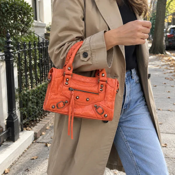 Immagine generata con IA: borsa It Girl piccola, corallo, in un contesto quotidiano
