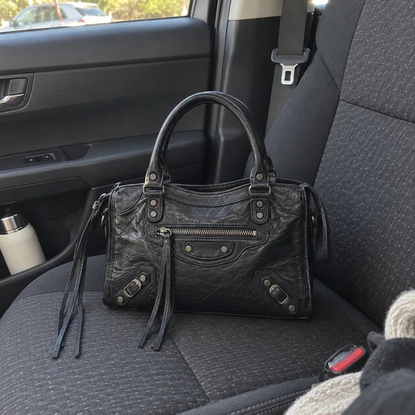 Immagine generata con IA: borsa It Girl piccola, nera, in un contesto quotidiano