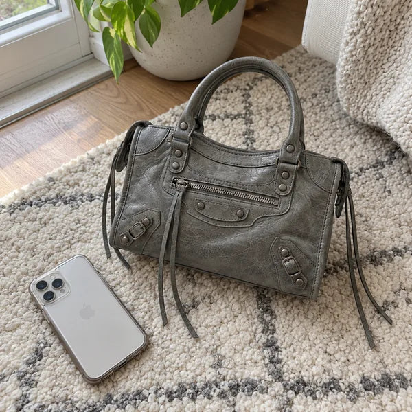 Immagine generata con IA: borsa It Girl piccola, grigio scuro, in un contesto quotidiano