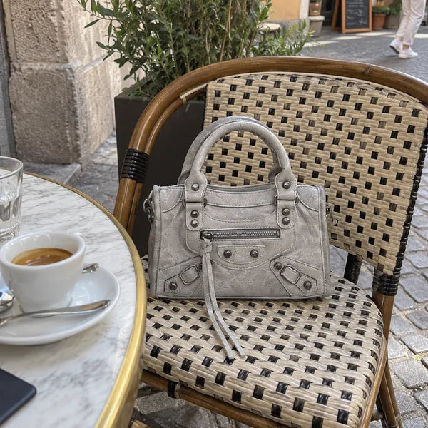 Immagine generata con IA: borsa It Girl piccola, grigio chiaro, in un contesto quotidiano