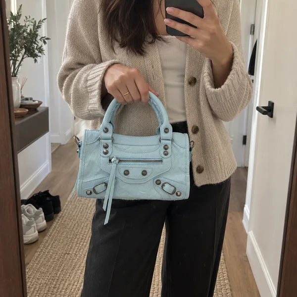 Immagine generata con IA: borsa It Girl piccola, azzurro baby, in un contesto quotidiano