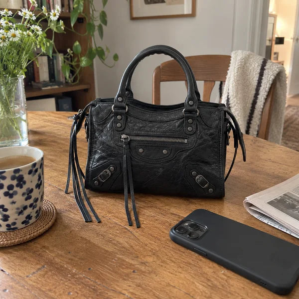 Immagine generata con IA: borsa It Girl piccola, nera, in un contesto quotidiano