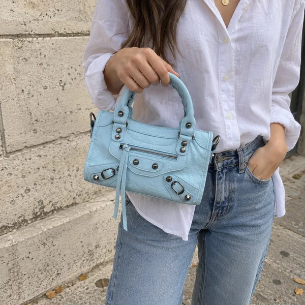AI-generated image: bag It Girl small, baby blue, in an everyday setting